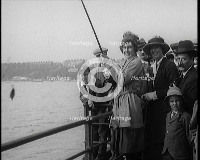 Female Civilian Fishing from a Pier Watched by a Small Crowd, 1920. Creator: British Pathe Ltd.