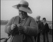 Female Civilian Removing Seaweed from a Fishing Hook Whilst Fishing from a Pier, 1920. Creator: British Pathe Ltd
