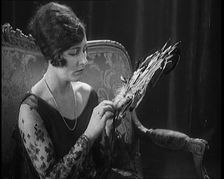 Female Civilian Seating Handling a Fan Made of Feathers, 1920. Creator: British Pathe Ltd