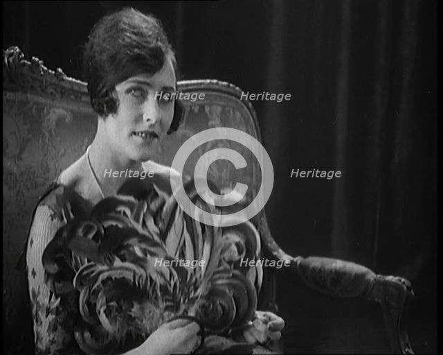 Female Civilian Using a Fan Made of Feathers, 1920. Creator: British Pathe Ltd.