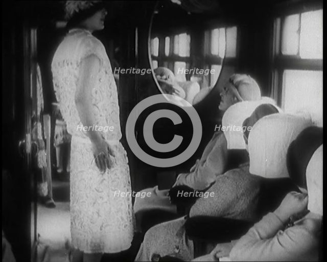 Female Civilian Wearing a Dress and Hat Modelling in Front of a Small Audience Inside a..., 1920. Creator: British Pathe Ltd.