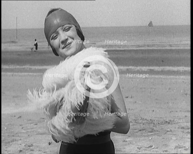 Female Civilian Wearing a Swimsuit Holding a Feathered Parasol at the Beach, 1920. Creator: British Pathe Ltd.