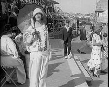 Female Civilian Wearing Smart outfit and Hat Holding a Parasol Walking Towards the Camera..., 1920. Creator: British Pathe Ltd