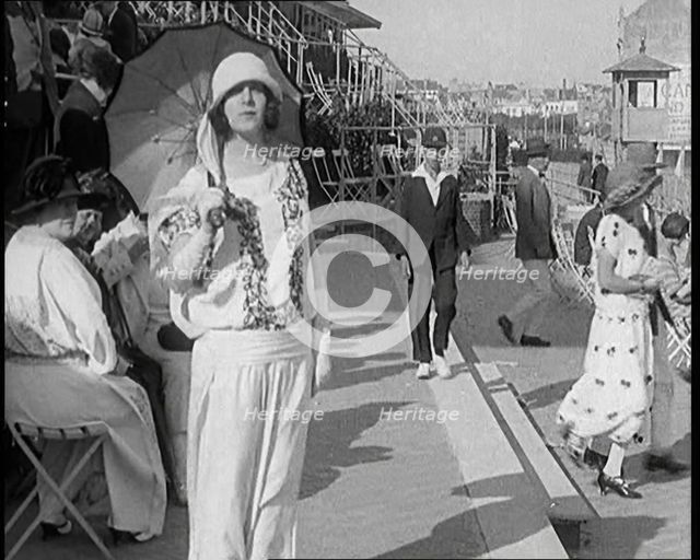 Female Civilian Wearing Smart outfit and Hat Holding a Parasol Walking Towards the Camera..., 1920. Creator: British Pathe Ltd.