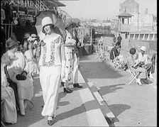 Female Civilian Wearing Smart outfit and Hat Holding a Parasol Walking Towards the Camera..., 1920. Creator: British Pathe Ltd