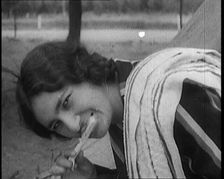Female Civilian with Dark Hair Brushing Her Teeth Outdoors, 1920. Creator: British Pathe Ltd