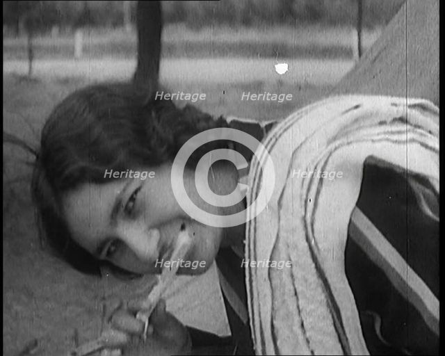 Female Civilian with Dark Hair Brushing Her Teeth Outdoors, 1920. Creator: British Pathe Ltd.