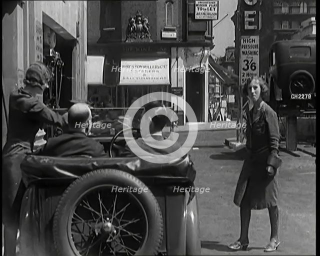 Female Civilians Working Petrol Pumps in a Garage and Filling up a Car, 1931. Creator: British Pathe Ltd.