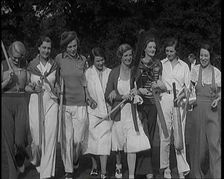 Female Civilians Carrying Cricket Bats Walking in a Line, 1920s. Creator: British Pathe Ltd