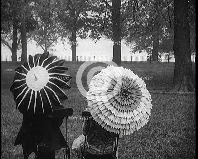 Female Civilians Holding Ornate Parasols in a Park, 1920. Creator: British Pathe Ltd.
