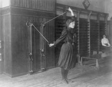 Female student exercising with a wall-mounted device using ropes and..., Washington, DC, (1899?). Creator: Frances Benjamin Johnston
