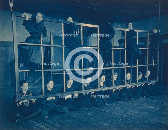 Female students posing with exercise equipment in a gymnasium, Western..., Washington DC, (1899?). Creator: Frances Benjamin Johnston.