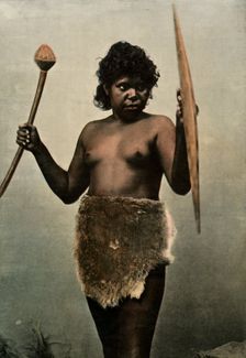 Femme Australienne Chargee Des Armes De Son Mari (Austrailan Woman with Husbands Weapons), 1900. Creator: Unknown