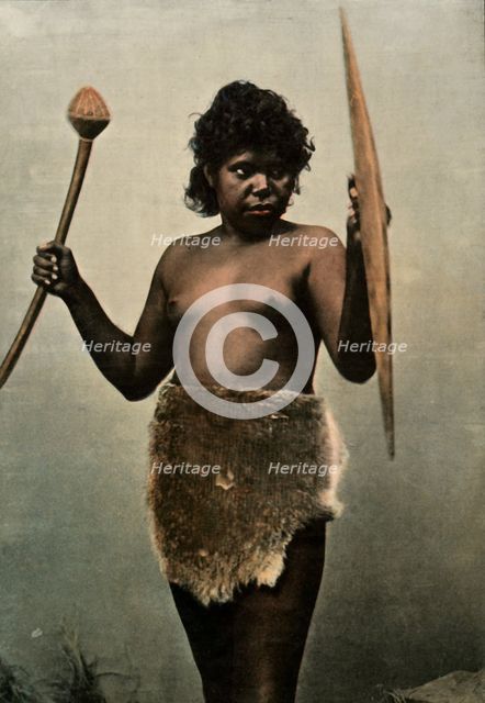 'Femme Australienne Chargee Des Armes De Son Mari', (Austrailan Woman with Husbands Weapons), 1900. Creator: Unknown.