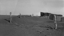 Fence corner and outbuilding being buried by dust, Mills, New Mexico, 1935. Creator: Dorothea Lange