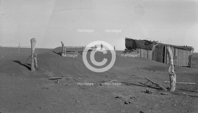 Fence corner and outbuilding being buried by dust, Mills, New Mexico, 1935. Creator: Dorothea Lange.