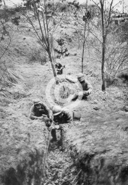 Fench sappers in gas masks re-laying telephone lines after a bombardment, 1918. Artist: Unknown
