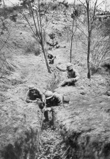 Fench sappers in gas masks re-laying telephone lines after a bombardment, 1918