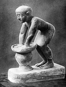 Figure of an Ancient Egyptian brewer pressing out fermented bread in a basket, c1910