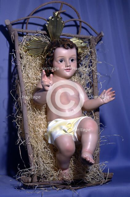 Figure of baby Jesus in the crib.