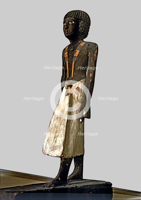 Figurine of a man for a tomb, made of polychromed wood, side view.