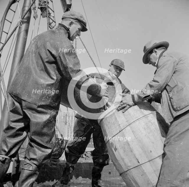 Filling a barrel with codfish at the Fulton fish market, New York, 1943. Creator: Gordon Parks.