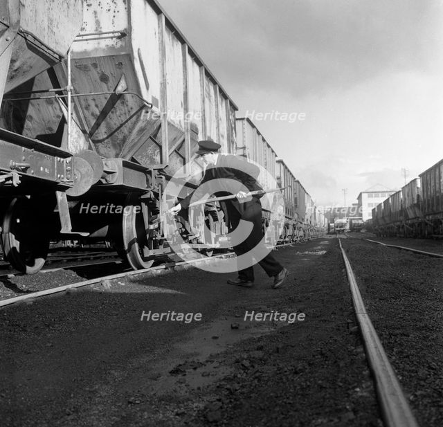 Final adjustments to a rail truck hauling coal from Lynemouth Colliery, Northumberland, 1963.  Artist: Michael Walters