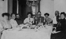 Fire Chief A. F. Domishkevich Sitting at a Table Set for a Holiday Together with..., early 20th cent Creator: Unknown