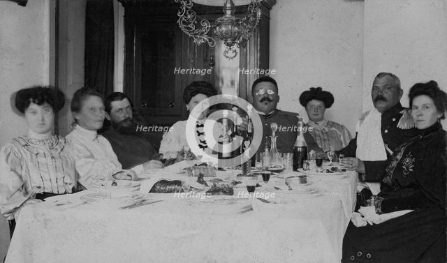 Fire Chief A. F. Domishkevich Sitting at a Table Set for a Holiday Together with..., early 20th cent Creator: Unknown.