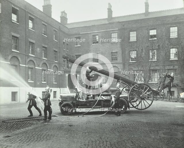 Fireman using a hose, London Fire Brigade Headquarters, London, 1910. Artist: Unknown.