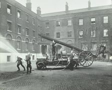 Fireman using a hose, London Fire Brigade Headquarters, London, 1910