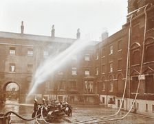 Firemen demonstrating hoses worked by a petrol motor pump, London Fire Brigade Headquarters, 1909