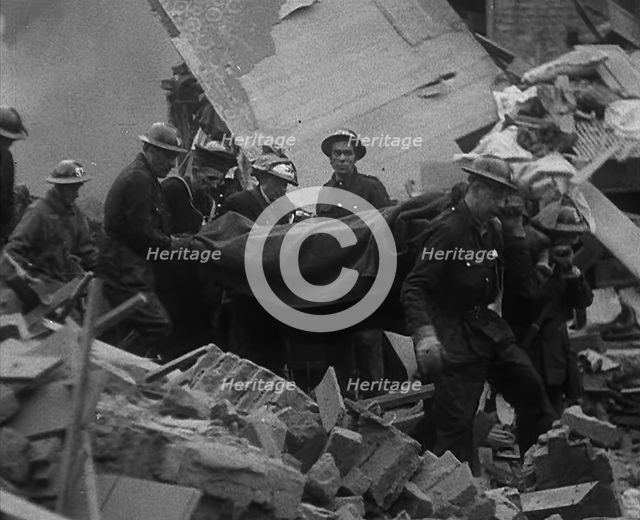 Firefighters Carrying Out a Corpse from a Bombed Out Building, 1940. Creator: British Pathe Ltd.