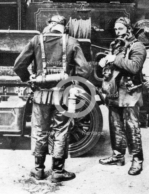 Firefighters donning smoke helmets, Farringdon Street rubber works, London, 1926-1927. Artist: Unknown