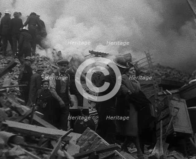 Firefighters Helping an Injured Civilian During the Blitz, 1940. Creator: British Pathe Ltd.