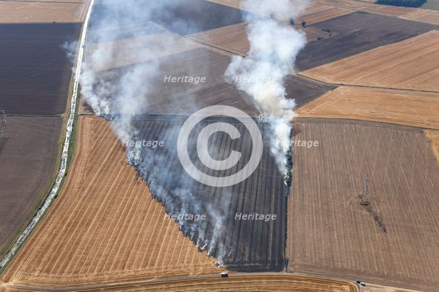 Fires in an arable field engulfing an electricty pylon, Amcotts, North Lincolnshire, 2022. Creator: Emma Trevarthen.