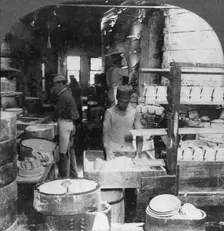 Firing tableware in the Noted Pottery Centre, Trenton, New Jersey, USA, early 20th century. Artist: Keystone View Company