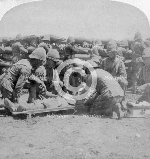 First aid to a wounded fusilier, Honey Nest Kloof Battle, Boer War, South Africa, February 1900.Artist: Underwood & Underwood