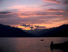 Fisherman at sunset, Lake Maggiore, Italy. Creator: Peter Thompson