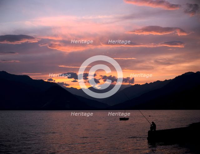 Fisherman at sunset, Lake Maggiore, Italy. Creator: Peter Thompson.