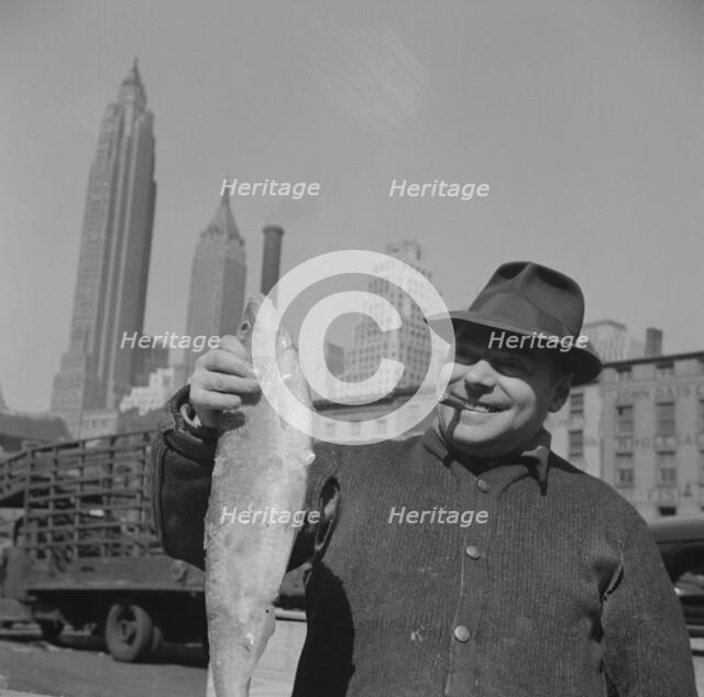 Fisherman holding a large catch at the Fulton fish market, New York, 1943. Creator: Gordon Parks.