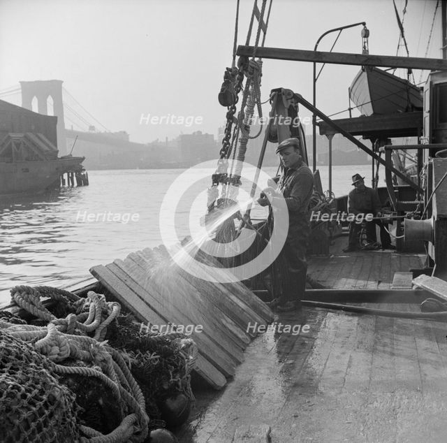 Fisherman washing off the slats used to hold fish during the trip down from New..., New York, 1943. Creator: Gordon Parks.