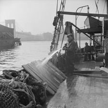 Fisherman washing off the slats used to hold fish during the trip down from New..., New York, 1943. Creator: Gordon Parks