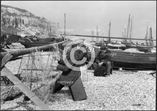 Fishermen mending nets on the beach, Hastings, East Sussex, 1925-1939. Creator: J Dixon Scott.