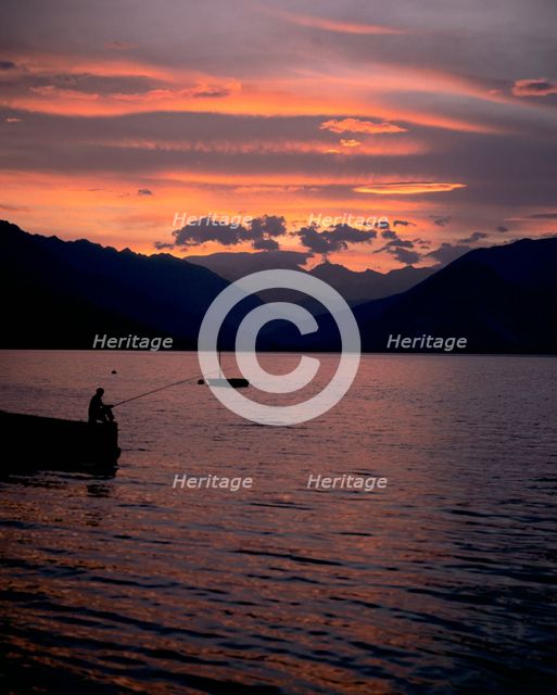 Fishing at sunset, Lake Maggiore, Italy. Creator: Peter Thompson.