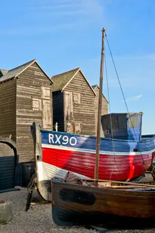 Fishing boat on the beach in front of the net shops Hastings, East Sussex, c1980-c2017. Artist: Historic England Staff Photographer