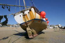 Fishing boat in the harbour at low tide, St Ives, Cornwall. Creator: Peter Thompson