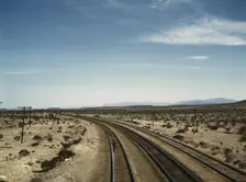 Flagman standing at a distance behind a Santa Fe R.R. west bound freight..., Bagdad, Calif., 1943. Creator: Jack Delano