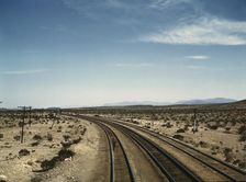 Flagman standing at a distance behind a Santa Fe R.R. west bound freight..., Bagdad, Calif., 1943. Creator: Jack Delano