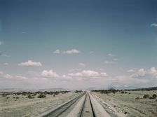 Flagman standing behind his train to flag oncoming trains at a small siding..., New Mexico, 1943. Creator: Jack Delano